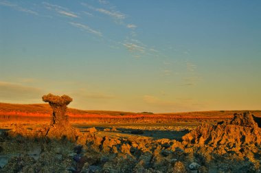 Shell-covered rock formations, blood-red rock wall and soft orange-blue sky at sunset, at the coast of Cape Keraudren, a remote area between Port Hedland and Broome in Western Australia. clipart