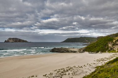 Batı Avustralya 'nın güney kıyısındaki ücra sahil ve kıyı tepeleri bulutlu bir gökyüzünün altında. Mandalay Sahili, Rüzgarlı Liman, Chatham Adası 'na yakın.