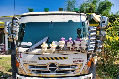 Front of a Hino Dominator 500 truck, decorated with Michelin mascots and dozens of rear view mirrors, Lom Sak, Thailand clipart