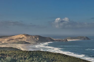 Cape Maria van Diemen 'in panoramik manzarası, Northland' in kuzeyinde, Kuzey Adası, Yeni Zelanda, yumuşak akşam ışığında. Geniş koy, sahil ve büyük kum tepeleri.