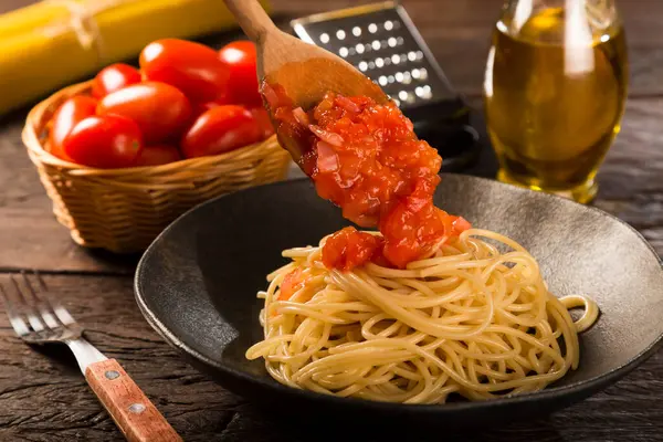 在番茄酱和罗勒中加入意大利面 — 图库照片