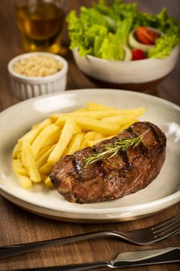 Izgara biftek, patates kızartması ve salata..