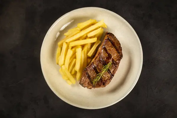 Dish with grilled steak and french fries.