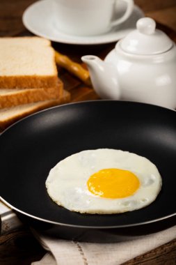 Breakfast with fried egg in the frying pan. clipart