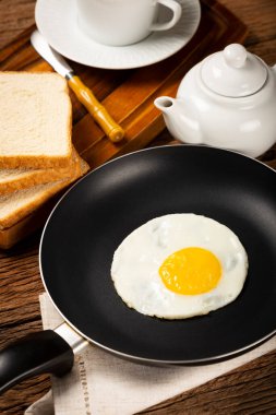 Breakfast with fried egg in the frying pan. clipart