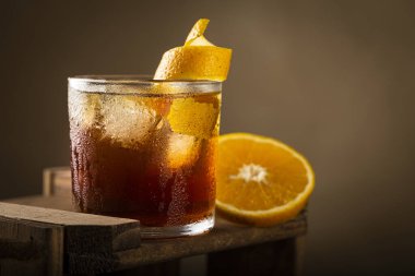 Ahşap arka planda portakallı Negroni kokteyli..