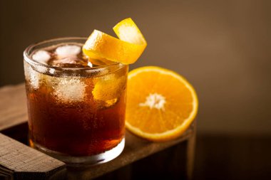 Ahşap arka planda portakallı Negroni kokteyli..
