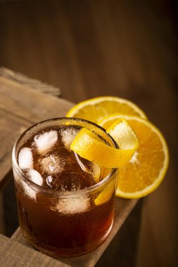 Ahşap arka planda portakallı Negroni kokteyli..