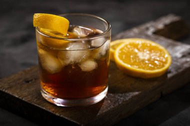 Koyu arkaplanda portakallı Negroni kokteyli.