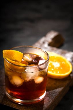 Koyu arkaplanda portakallı Negroni kokteyli.