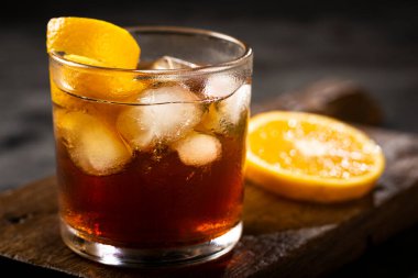 Koyu arkaplanda portakallı Negroni kokteyli.