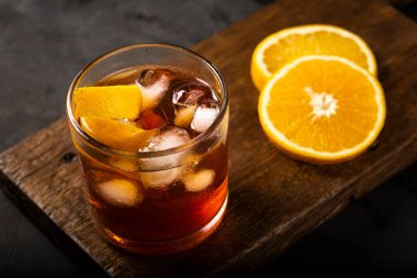 Koyu arkaplanda portakallı Negroni kokteyli.
