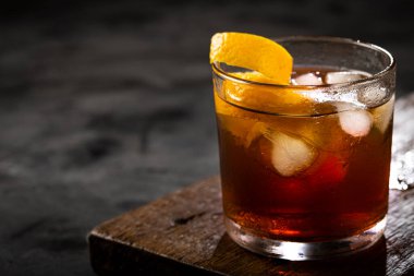 Koyu arkaplanda portakallı Negroni kokteyli.