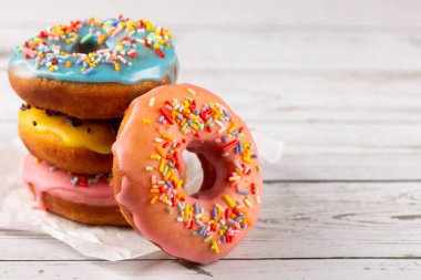 Masanın üzerinde çeşitli renkli çörekler var..