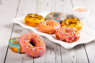 Masanın üzerinde çeşitli renkli çörekler var..