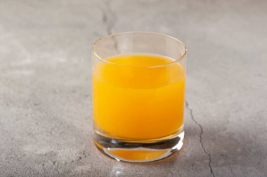 Masada portakal suyu olan bir bardak..