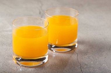 Masada portakal suyu olan bir bardak..