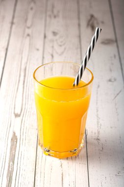 Masada portakal suyu olan bir bardak..