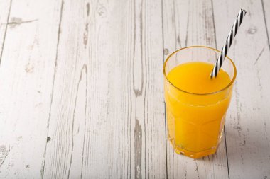 Masada portakal suyu olan bir bardak..