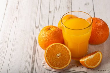 Masada portakal suyu olan bir bardak..