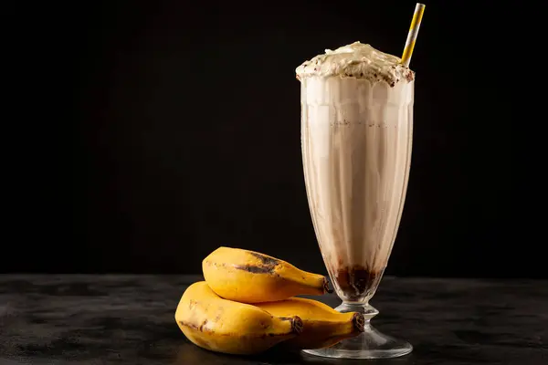 Vanilla milkshake with whipped cream, banana and chocolate syrup.