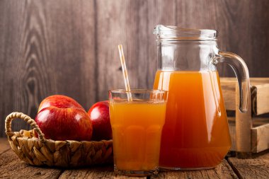 Elma suyu ve kırmızı elmalar masada..