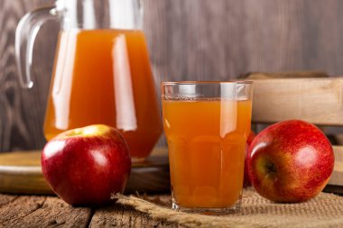 Elma suyu ve kırmızı elmalar masada..