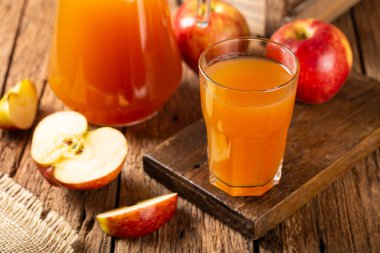 Elma suyu ve kırmızı elmalar masada..