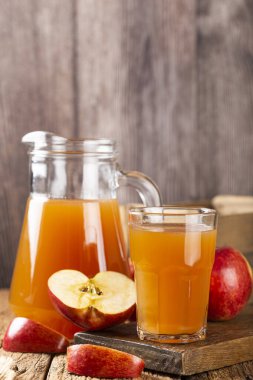 Apple juice and red apples on the table. clipart