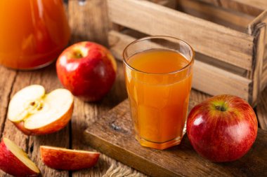 Elma suyu ve kırmızı elmalar masada..