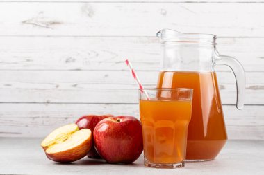 Elma suyu ve kırmızı elmalar masada..