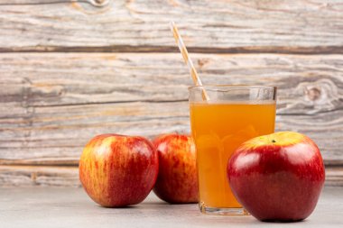 Elma suyu ve kırmızı elmalar masada..