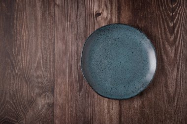 Tahta masadaki boş tabak. Resmin üst görünümü.
