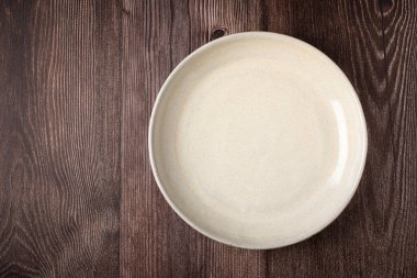 Tahta masadaki boş tabak. Resmin üst görünümü.