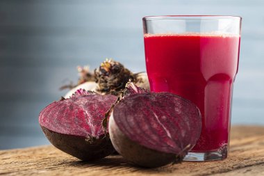 Ahşap masada cam bir fincanda kırmızı pancar suyu.