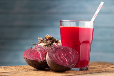 Ahşap masada cam bir fincanda kırmızı pancar suyu.