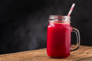 Ahşap masada cam bir fincanda kırmızı pancar suyu.