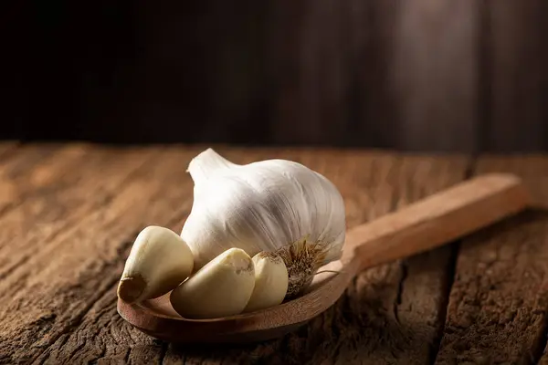Garlic bulb and garlic cloves on the wooden table.