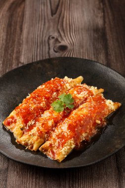 Kıyma ve domates sosuyla doldurulmuş krep ve rendelenmiş peynir..