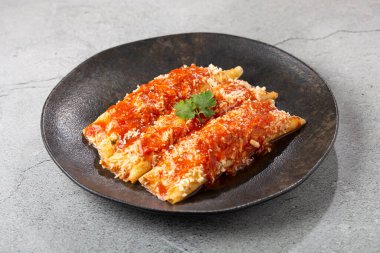 Kıyma ve domates sosuyla doldurulmuş krep ve rendelenmiş peynir..