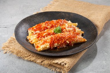 Kıyma ve domates sosuyla doldurulmuş krep ve rendelenmiş peynir..