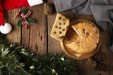 Tahta bir masanın üzerinde çikolata parçacıkları olan leziz bir panettone. Chocottone