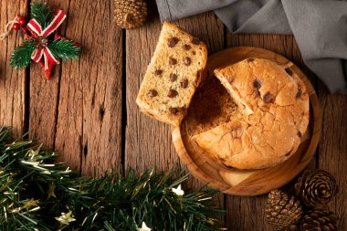 Tahta bir masanın üzerinde çikolata parçacıkları olan leziz bir panettone. Chocottone