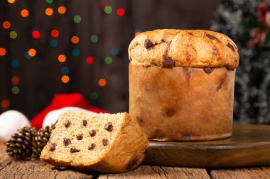 Noel için süslenmiş bir masanın üzerinde çikolata parçacıkları olan leziz bir panettone..