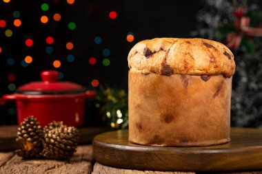 Noel için süslenmiş bir masanın üzerinde çikolata parçacıkları olan leziz bir panettone..