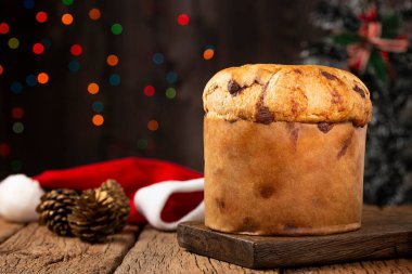 Noel için süslenmiş bir masanın üzerinde çikolata parçacıkları olan leziz bir panettone..