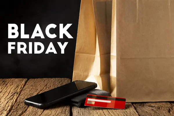 Paper bag, smartphone, wallet and credit card. Black Friday.