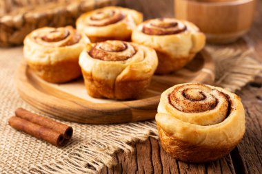 Ahşap arka plan üzerinde rulo tarçın.