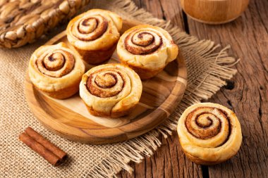 Ahşap arka plan üzerinde rulo tarçın.