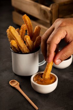 Sugary churros with dulce de leche. clipart